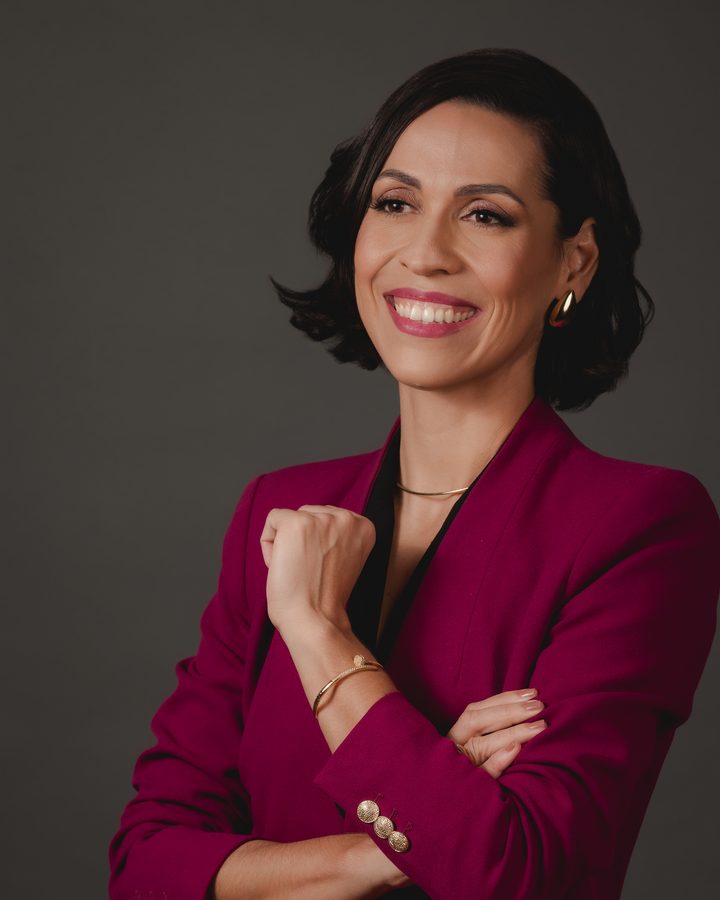 Dra. Cinara Costa sorrindo, de blazer vinho